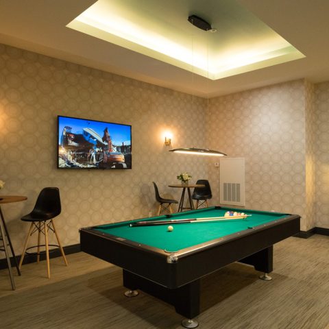 Pool table and TV in game room at MKT apartments in Wilmington